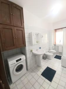 bagno con lavandino e servizi igienici e lavatrice. di casa fronte mare ad Alba Adriatica