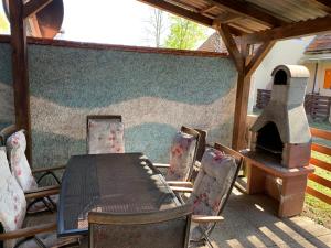 un patio con mesa, sillas y horno en Lotty, en Čatež ob Savi