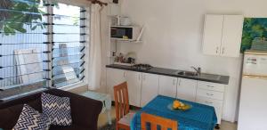 a kitchen with a table and a kitchen with a sink at Herons Reef Holiday Apartments in Rarotonga