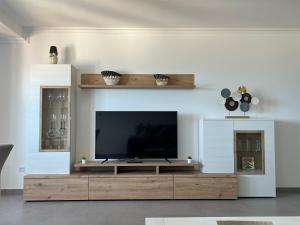 A television and/or entertainment centre at Apartamentos Maria de Lucia- Ático