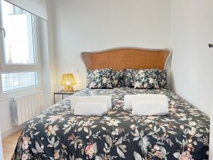 um quarto com uma cama grande e uma colcha floral em Ansar Suite em Torrelavega