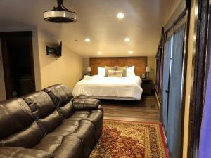 a living room with a bed and a leather couch at Zion Cliff Lodge in Hildale