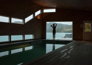 a woman standing on the edge of a swimming pool at Explora en Torres del Paine - All Inclusive in Torres del Paine
