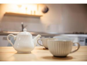 a tea pot and two cups on a wooden table at KONOHANA NO IORI - Vacation STAY 15340v in Mimasaka