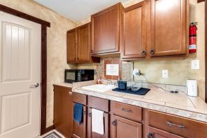 a kitchen with wooden cabinets and a sink at Hide Away Guest House in Azle