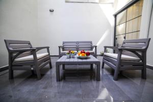 3 Stühle und ein Tisch mit einer Obstschale drauf. in der Unterkunft Modern Super Chic Duplex with a Terrace at the heart of city! in Istanbul