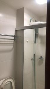 a bathroom with a toilet and a glass shower stall at Veredas do Rio Quente Hotel Service in Rio Quente