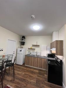 a kitchen with a table and a white refrigerator at Furnished and Cozy in Surrey