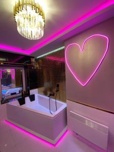 una habitación con un signo cardiaco en la pared en Apartament "Love Paradise" Centrum z dużą wanną dla Dwojga, en Gniezno