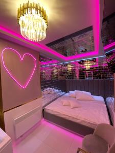 Un dormitorio con una cama con un signo cardiaco. en Apartament "Love Paradise" Centrum z dużą wanną dla Dwojga, en Gniezno