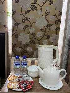 a table with a tea kettle and water bottles at Iso Hostel in Tashkent