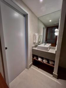 a bathroom with a sink and a large mirror at Hotel Fazenda Brisa Itu in Itu