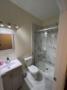 a bathroom with a toilet and a shower and a sink at Furnished and Cozy in Surrey