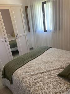 sypialnia z łóżkiem i dużym lustrem w obiekcie Viviendas uso turístico REME I w mieście Foz