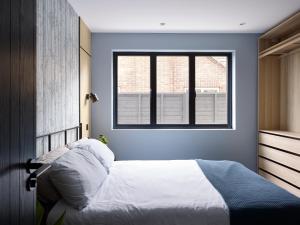a bedroom with a white bed and a window at Chess Valley modern home stay in Rickmansworth