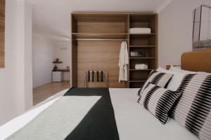 um quarto com uma cama com duas almofadas em Açores Premium- 5 Minutos do Moinhos de Vento em Porto Alegre