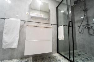 a bathroom with a glass shower stall with towels at Céline hôtel le miridan in Plombières-les-Bains