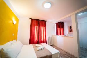 a hotel room with a bed and red curtains at Céline hôtel le miridan in Plombières-les-Bains