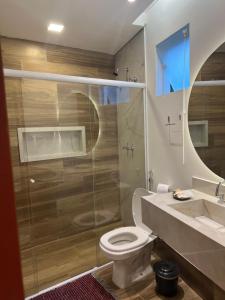 uma casa de banho com um WC e uma cabina de duche em vidro. em Chalés Pôr do Sol em Tiradentes