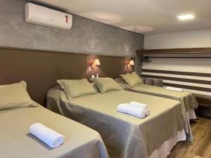 duas camas num quarto de hotel com toalhas em Chalés Pôr do Sol em Tiradentes