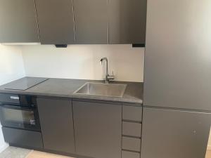 eine Küche mit einer Spüle und einem Kühlschrank in der Unterkunft Apartment in Sollentuna Centrum 1205 in Sollentuna