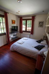 sypialnia z dużym łóżkiem i telewizorem w obiekcie Espectacular Casa con Piscina en Allariz w mieście Allariz