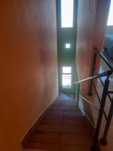 escalera con barandilla y ventana en Apartamentos km4, en Comodoro Rivadavia