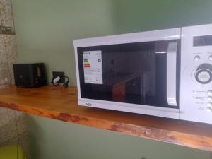 a microwave sitting on top of a wooden shelf at Apartamentos km4 in Comodoro Rivadavia