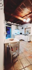 een keuken met een tafel en een witte tafel en stoelen bij Casa Lale in Corchiano