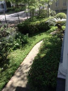 a garden with a walkway in the grass at The Queen Anne in New Orleans