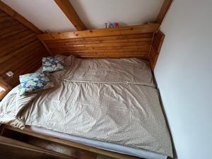 a bed with a wooden headboard and two pillows at Aqua Faház in Mesteri