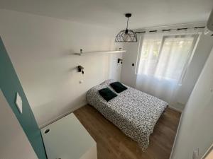 Un dormitorio pequeño con una cama y una ventana. en Appartement 2 chambres en bord de mer 46m2, en Sète