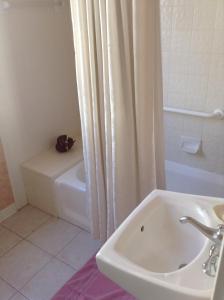 a bathroom with a sink and a bath tub at The Queen Anne in New Orleans