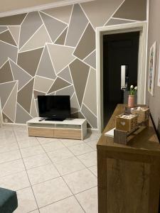 ein Wohnzimmer mit einem TV und einer Wand in der Unterkunft HomeSea Trapani in Trapani