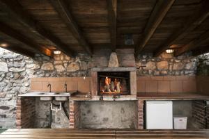 a kitchen with a fireplace in a stone wall at El Cabañon de Pimiango in Pimiango