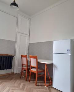 Big and cozy bedroom in Krakow في كراكوف: مطبخ مع طاولة وكراسي وثلاجة