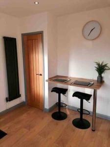 a room with a desk with two stools and a table at Modern Coastal 2 Bedroom Home to Relax and Unwind in Heacham