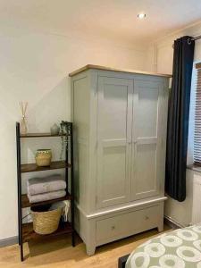 a white cabinet in a room with a shelf at Modern Coastal 2 Bedroom Home to Relax and Unwind in Heacham