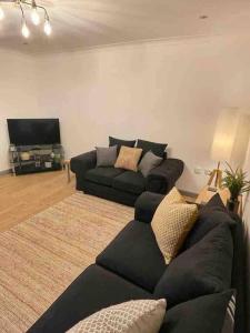 a living room with a couch and a flat screen tv at Modern Coastal 2 Bedroom Home to Relax and Unwind in Heacham