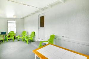 a waiting room with green chairs and a table at Ormond Beach Vacation Rental - Walk to Ocean! in Ormond Beach