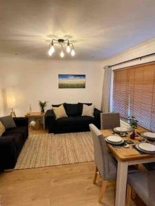 a living room with a table and a couch at Modern Coastal 2 Bedroom Home to Relax and Unwind in Heacham