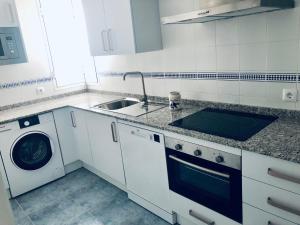 Una cocina blanca con fregadero y lavadora. en Sol y playa Sanlúcar, en Sanlúcar de Barrameda 8 fotos más
