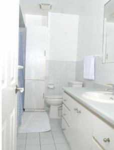 a white bathroom with a toilet and a sink at Raised bungalo in Toronto