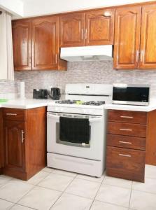 a kitchen with a white stove and wooden cabinets at Raised bungalo in Toronto