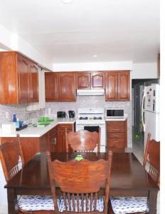 a kitchen with wooden cabinets and a table with chairs at Raised bungalo in Toronto