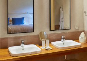 La salle de bains est pourvue de 2 lavabos blancs et d'un lit. dans l'établissement Explora Valle Sagrado, à Urubamba