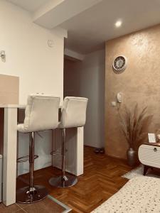 a barber shop with two white chairs in a room at Apartman Puket in Kraljevo