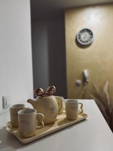 a tray with three cups and a tea kettle on it at Apartman Puket in Kraljevo
