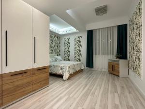Un dormitorio con una cama y suelo de madera. en Golden Garden Luxury Apartment in Bucharest, en Bucarest