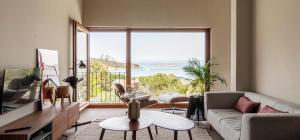 a living room with a couch and a large window at INSUA BEACH HOUSE in Pontevedra